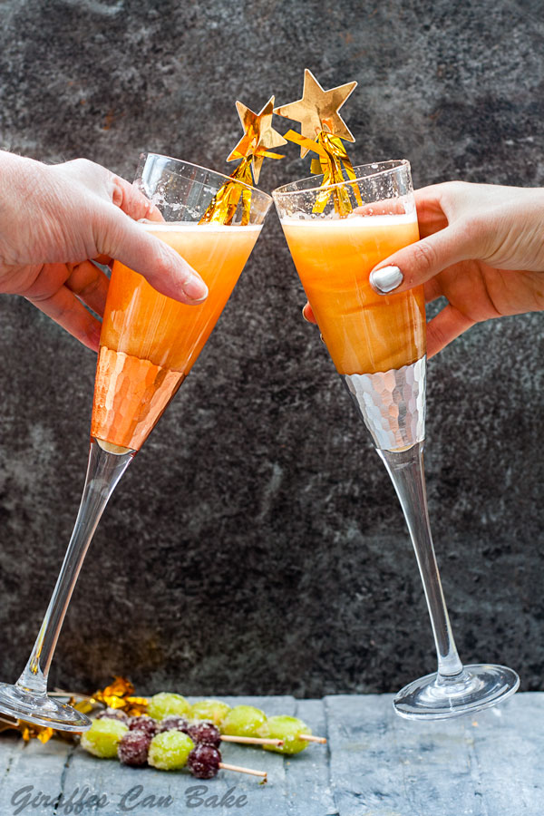 Shimmery New Years Eve Cocktail - two champagne glasses being clinked together in a cheers fashion